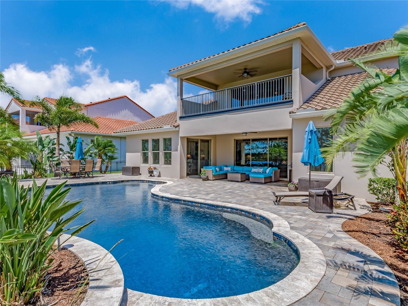 back of home with covered patio and large pool